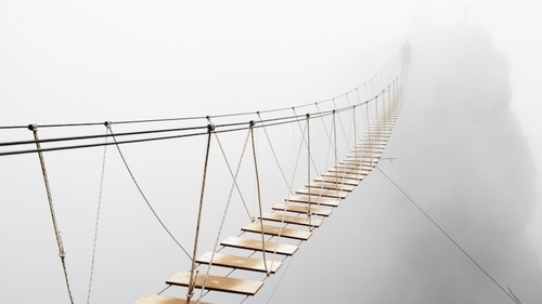 The image depicts a hanging bridge with a blur white background.